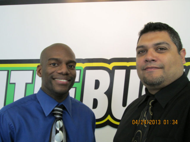 two men standing in front of a TitleBucks sign